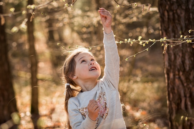 niña en la naturaleza examina plantas