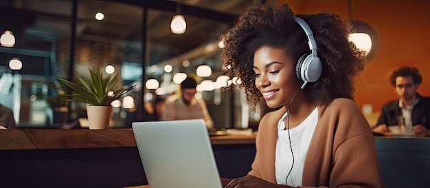 Niña negra estudiando en línea con computadora portátil y auriculares en un café feliz y tomando notas