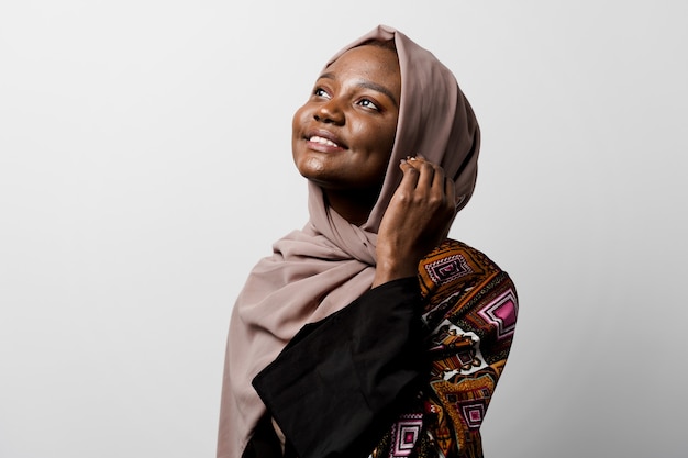 La niña negra soñadora usó hijab sonreír y regocijarse Mujer musulmana feliz posando. Atractiva mujer africana.