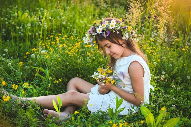 Niña niña con flores silvestres en verano