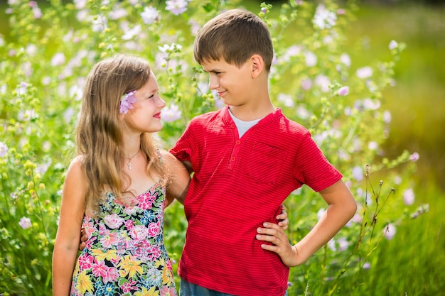 Niña y niño abrazándose en el exterior