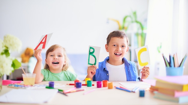 Una niña y un niño aprenden en casa.