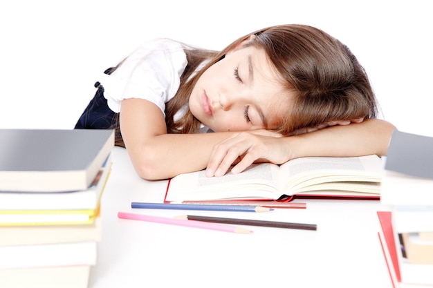 Niña niño cansado durmiendo en el escritorio en la escuela.