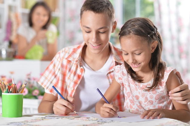 Niña y niño dibujando con lápices