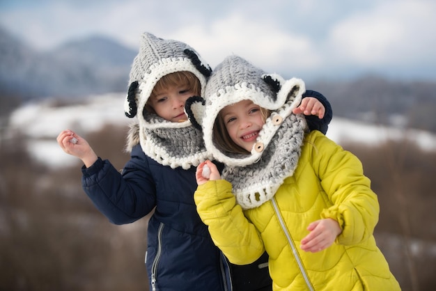Niña y niño disfrutando del invierno jugando en el bosque de invierno niños hermanos divirtiéndose y hu