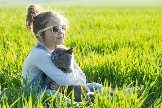 Niña niño divirtiéndose con gato en el parque