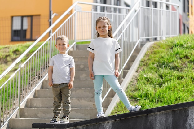 Niña y niño en el espacio de la camiseta blanca para su logotipo o diseño Mockup para imprimir