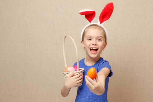 Niña niño feliz con orejas de conejo y huevos de pascua