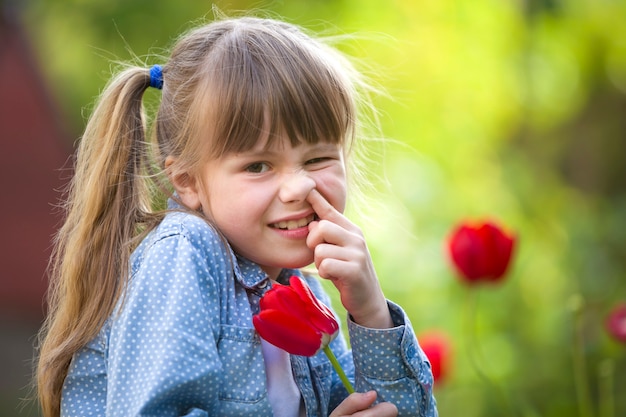 Niña niño con flor de tulipán rojo brillante