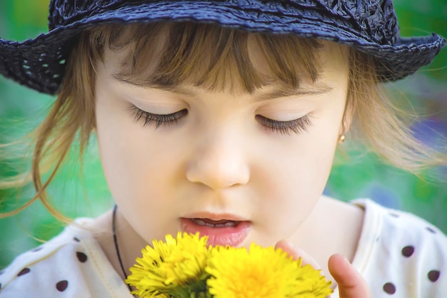 Niña, niño, flores de diente de león en la primavera juega. Enfoque selectivo