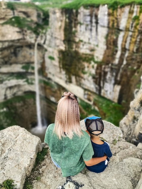 Una niña con un niño en el fondo de la cascada Tobot Khunzakh falls Daguestán Rusia 2021