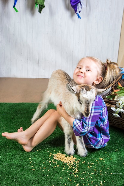 Niña niño jugando con cabras en tierras de cultivo