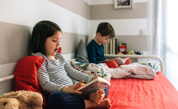 niña y niño leyendo un libro