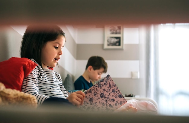 niña y niño leyendo un libro