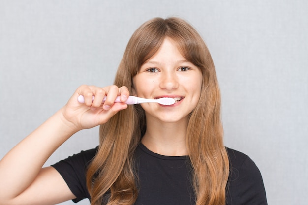 Niña niño lindo sonriente cepillándose los dientes