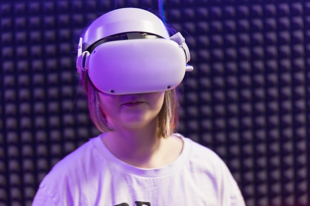 Niña niño niño jugando juego VR en gafas Espacio cibernético y juego virtual Concepto de uso de tecnologías modernas para el aprendizaje