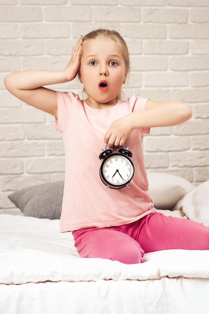 Foto niña niño en pijama con reloj