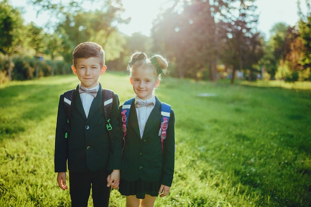 Niña y niño vestidos con uniforme escolar