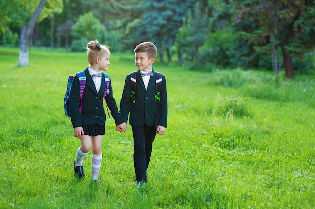 Niña y niño vestidos con uniforme escolar