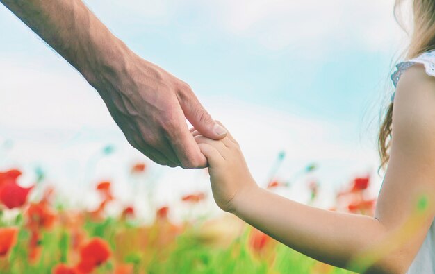 Niña de los niños en un campo con amapolas.