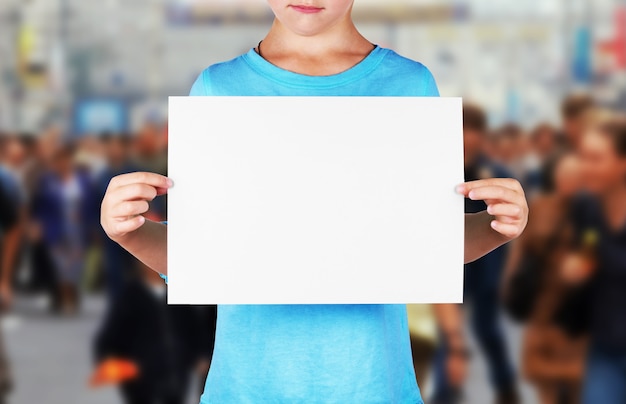 Foto niña no identificada sostiene una hoja de papel en blanco