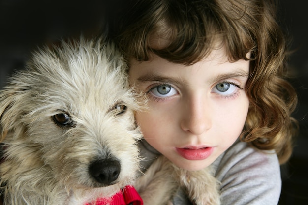 niña de ojos azules abrazar un cachorro peludo retrato de perro pequeño