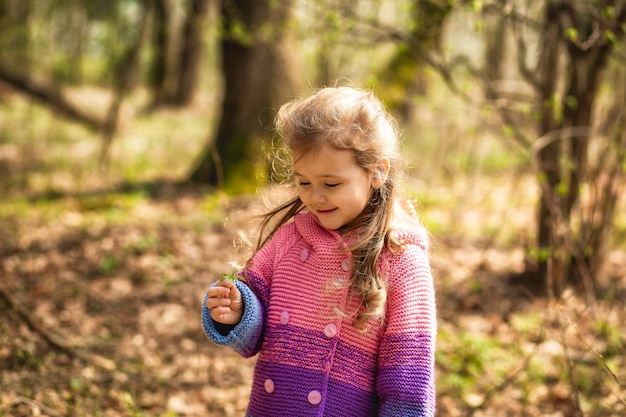 niña oliendo una flor