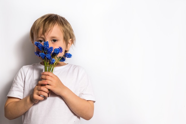 niña oliendo ramo de flores azules