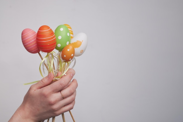 Una niña con orejas de conejo en las manos sostiene huevos de pascua sobre un fondo blanco el concepto de pascua