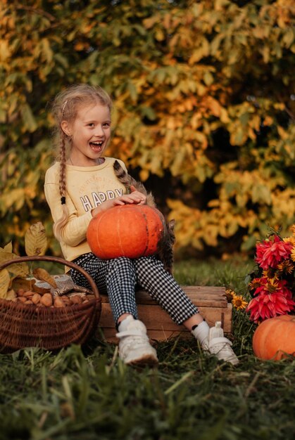 niña de otoño con una calabaza. hija y calabazas. hojas de otoño