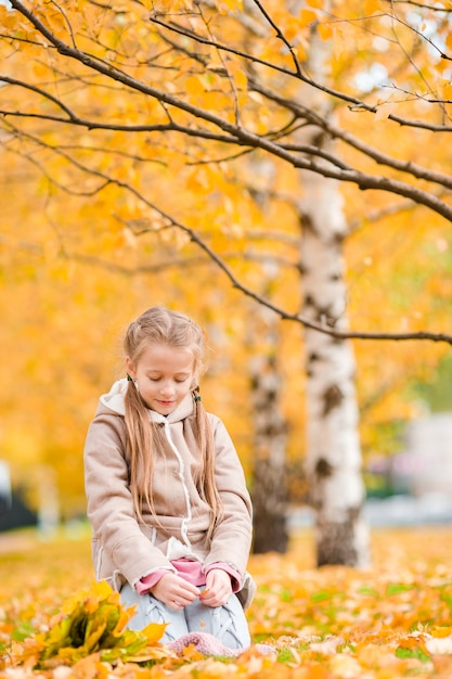 Niña con en otoño en el día de otoño