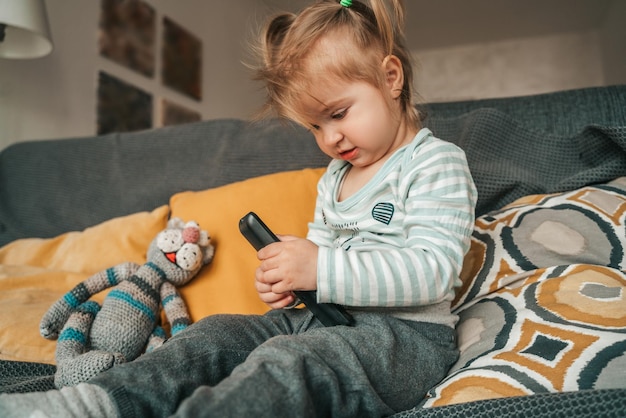 Niña pacífica jugando con el accesorio de TV