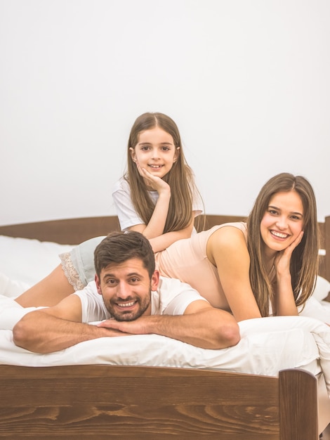 La niña y los padres se acostaron en la cama.