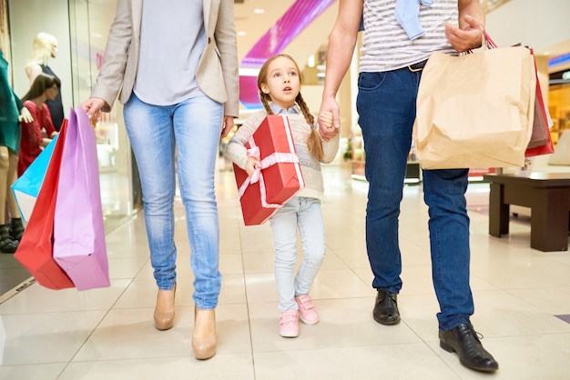 Niña con padres en compras de Navidad