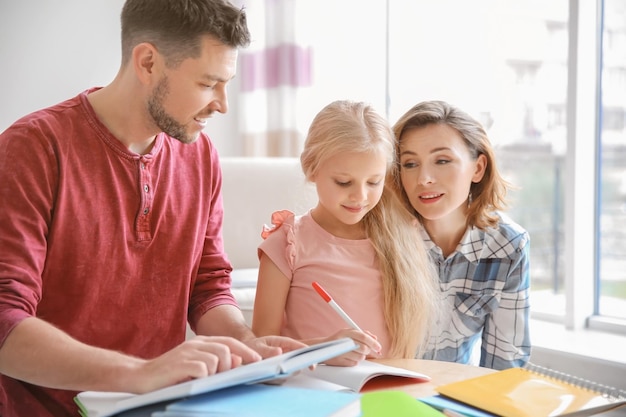 Niña con padres haciendo la tarea en casa