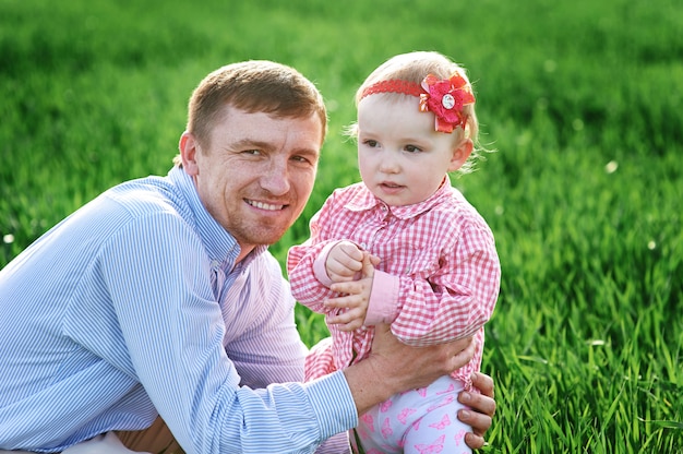 Niña con papá caminando en un prado