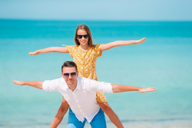 Niña y papá feliz divirtiéndose durante vacaciones en la playa