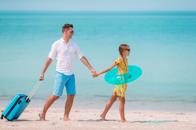 Niña y papá feliz divirtiéndose durante vacaciones en la playa