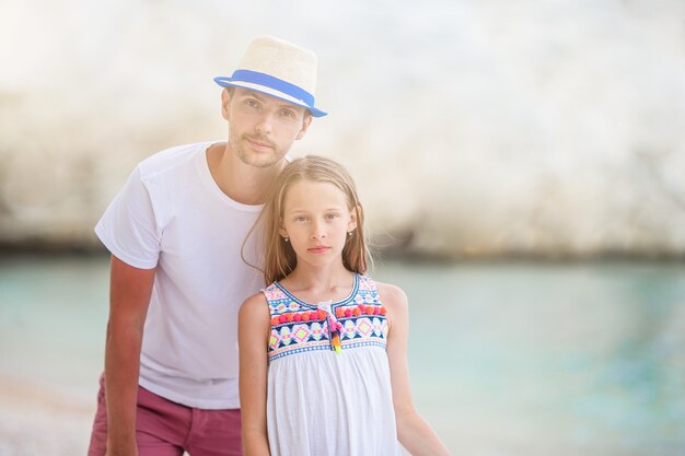 Niña y papá feliz divirtiéndose durante las vacaciones en la playa