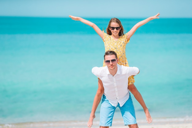 Niña y papá feliz divirtiéndose durante las vacaciones en la playa