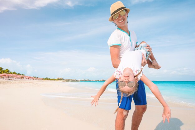 Niña y papá feliz divirtiéndose durante las vacaciones en la playa