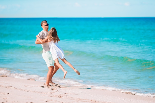 Niña y papá feliz divirtiéndose durante las vacaciones en la playa