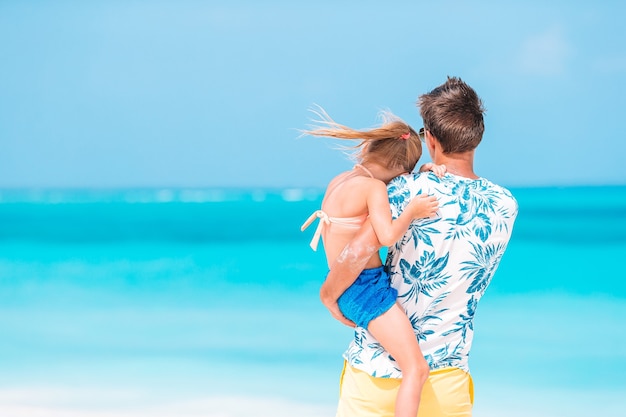 Niña y papá feliz divirtiéndose durante las vacaciones en la playa