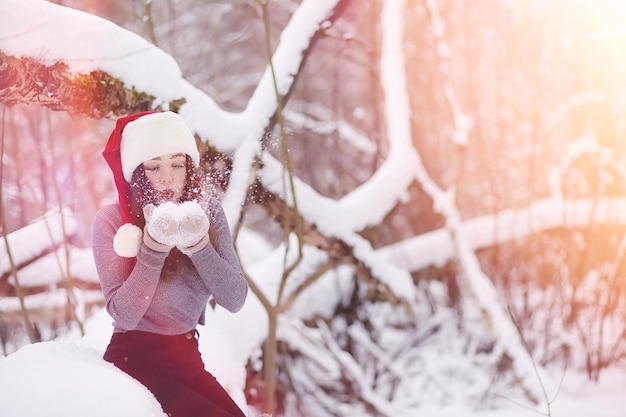 Una niña en un parque de invierno en un paseo. Vacaciones de Navidad en el bosque de invierno. Chica disfruta del invierno en el parque.