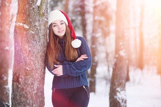 Una niña en un parque de invierno en un paseo. Vacaciones de Navidad en el bosque de invierno. Chica disfruta del invierno en el parque.
