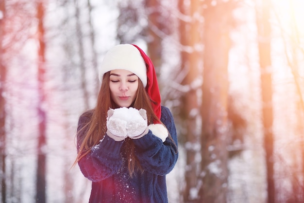 Una niña en un parque de invierno en un paseo. Vacaciones de Navidad en el bosque de invierno. Chica disfruta del invierno en el parque.