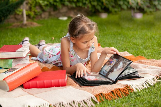 Niña en el parque mirando el álbum de fotos de la familia