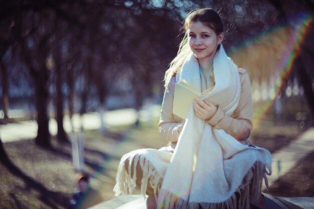 niña en el parque de otoño con un libro