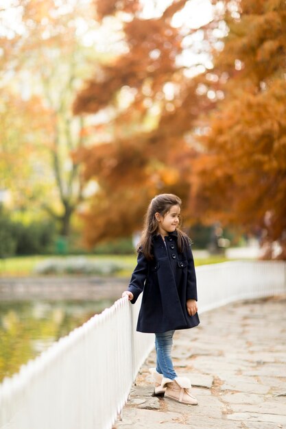 Niña en el parque de otoño