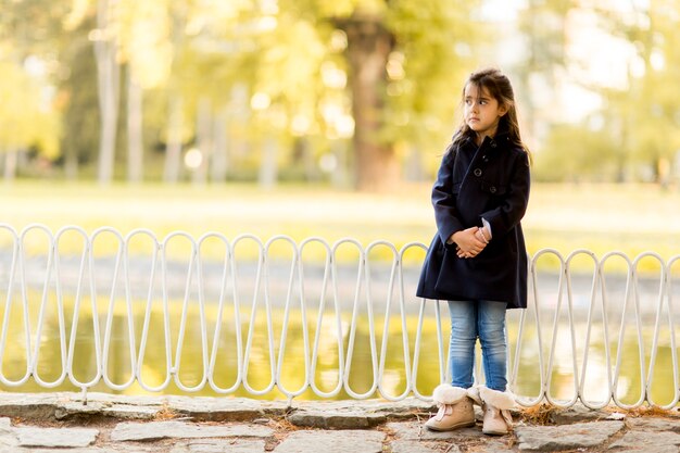 Niña en el parque de otoño